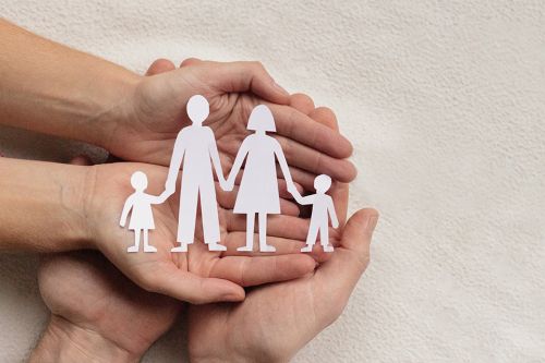 Foto: Hände mit Papierausschnitt einer Familie